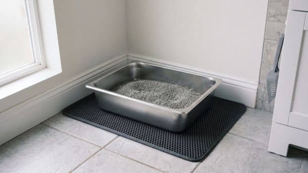 large stainless steel litter box on litter mat in laundry room