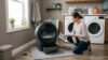How to clean an automatic litter box with a person wiping a self-cleaning litter box in a laundry room